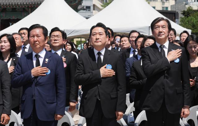 Jung Chung-rae left leader of the Democratic Party Jang Dong-hyeok center leader of the People Power Party and Cho Kuk right leader of the Rebuilding Korea Party perform a national salute during a ceremony marking the 46th anniversary of the May 18 Gwangju Democratic Uprising at May 18 Democracy Square in Gwangju on May 18 2026