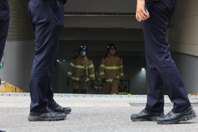 Firefighters emerge from the underground parking garage of the Sangdo 4-dong Community Complex in Sangdo-dong Seoul after extinguishing a fire on June 3 2026 AJP Han Jun-gu