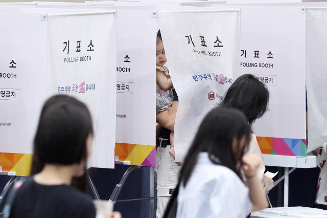 제9회 전국동시지방선거일인 3일 서울 잠전초 체육관에 마련된 잠실본동 제4·5·6투표소에서 한 아이가 기표소 밖을 보고 있다 사진연합뉴스