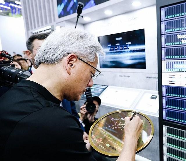 젠슨 황 엔비디아 CEO가 2일 대만 타이베이에서 개막한 컴퓨텍스 2026에 참석해 SK하이닉스 전시 부스에 소개된 양사의 협력 제품 전시물에 사인을 남기고 있는 모습 사진SK하이닉스