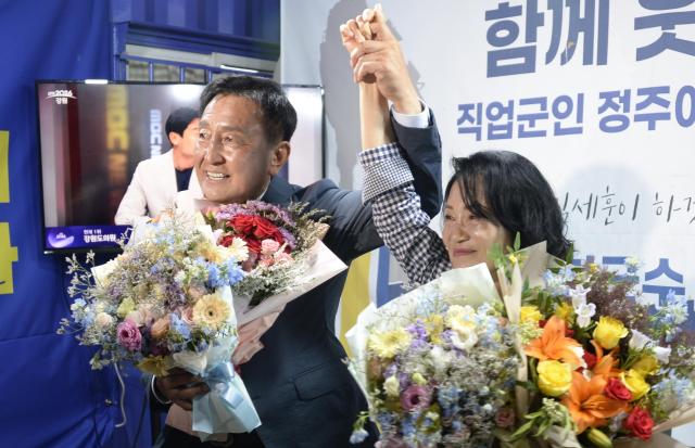 제9회 전국동시지방선거에서 당선된 김세훈 화천군수 당선인이 지난 3일 밤 화천읍 선거사무소에서 배우자 한영숙 여사와 함께 꽃다발을 받은 뒤 두 손을 맞잡아 들어 올리며 승리의 기쁨을 나누고 있다사진박종석 기자