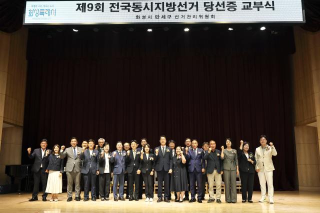 정명근 화성특례시장이 4일 시청 대강당에서 열린 제9회 전국동시지방선거 당선증 교부식에서 화성시만세구선거관리위원회 위원장 및 위원 당선인들과 기념촬영을 하고 있다 사진화성시