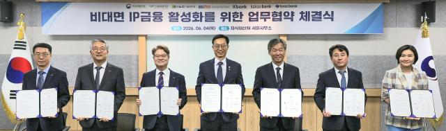 강승준 신용보증기금 이사장이 4일 서울 강남구 지식재산처에서 열린 ‘비대면 IP금융 지원 활성화를 위한 업무협약 체결식’에서 업무협약서를 들고 기념촬영을 하고 있다 사진신보