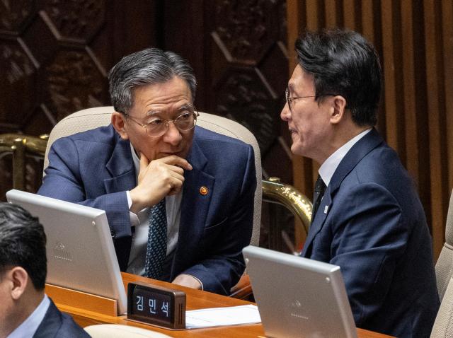 Justice Minister Jung Sung-ho left and Prime Minister Kim Min-seok right sit side by side and talk in the main chamber during the first plenary session of the 435th National Assembly at the National Assembly on May 7 2026 Yonhap 
