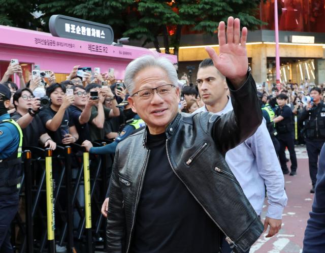 NVIDIA CEO Jensen Huang greets a crowd of people before attending a pork belly dinner gathering with SK Chairman Chey Tae-won LG Chairman Koo Kwang-mo and Naver Founder Lee Hae-jin held at a barbecue restaurant in Seogyo-dong Mapo District Seoul on June 5 Aju Business Daily Yoo Dae-gil