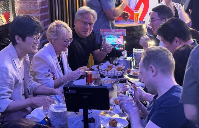Nvidia CEO Jensen Huang and his wife Lori Huang talk with SK Group Chairman Chey Tae-won LG Group Chairman Koo Kwang-mo and Naver founder Lee Hae-jin at a BBQ chicken restaurant in Hongdae Mapo District Seoul on June 5 2026 Yonhap
