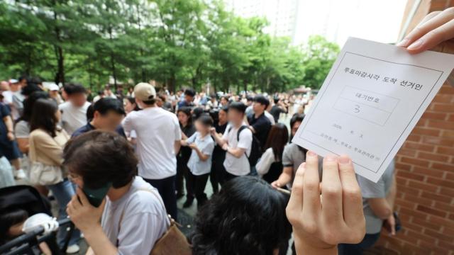 Voters wait in line due to a shortage of ballots at a polling station in Songpa-gu, Seoul, on June 3 during the local elections.