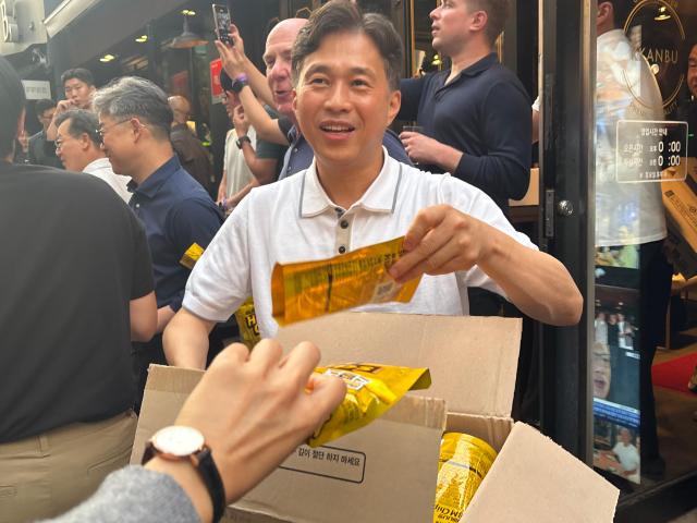 Kwak No-jung, president of SK Hynix, distributes HBM chips to waiting citizens during the dinner with NVIDIA on June 7 in Gangnam, Seoul.