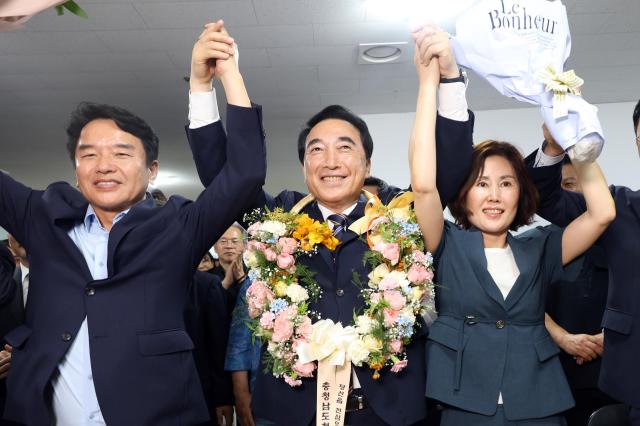 Park Soo-hyun, the newly elected governor of Chungnam, poses for a commemorative photo holding a bouquet.