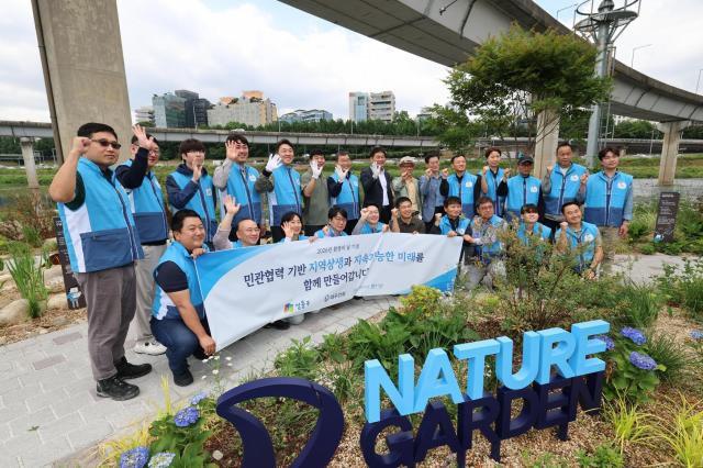 봉사활동 참석자들이 대우건설 Nature 앞에서 기념촬영을 하고 있다 사진대우건설