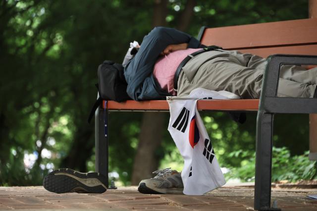 A protester rests on a bench inside Olympic Park in Songpa-gu Seoul on June 8 2026 AJP Han Jun-gu