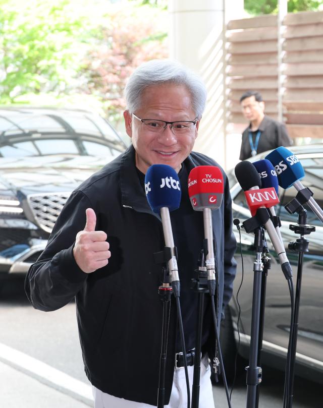 Jensen Huang, CEO of NVIDIA, gives a thumbs up while answering questions from reporters as he departs through the Seoul Gimpo Business Aviation Center after completing his visit to South Korea on June 9.