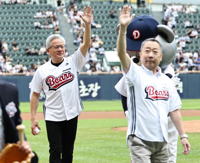 Nvidia CEO Jensen Huang leaves the field with Doosan Group Chairman Park Jeong-won after throwing the ceremonial first pitch at Jamsil Baseball Stadium in Seoul on June 7 2026 Yonhap