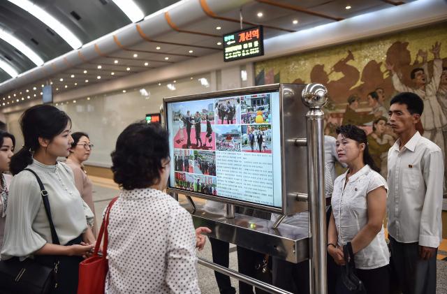 People look at a screen with the newspaper Rodongsinmun showing the news on the visit of Chinas President Xi Jinping in the Kaeson Station of the Pyongyang Metro in Pyongyang on June 9 2026 Chinas President Xi Jinping made a rare visit to North Korea on June 8 where he proclaimed a willingness to bring ties to new heights during a meeting with Kim Jong-un AFP-Yonhap 