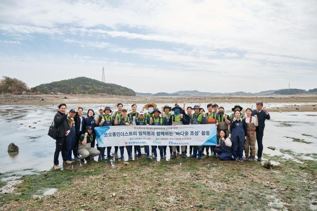 코오롱인더스트리가 한국수산자원공단 환경재단과 함께 추진한 ‘바다숲 조성 사업’을 완료했다 사진은 봉사자들이 충남 서산시 가로림만 잘피 이식 활동을 기념하는 모습 사진코오롱인더스트리