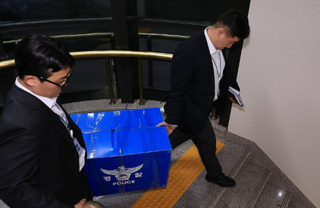 Members of the joint investigation team are seen leaving the Central Election Commission in Gwacheon after conducting a search on June 11.