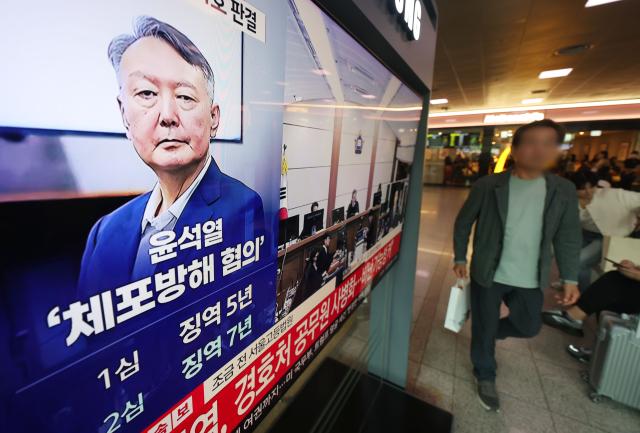 A live broadcast of the appellate ruling for former President Yoon Suk Yeol, charged with obstructing arrest, is shown on a TV in the Seoul Station concourse on April 29.
