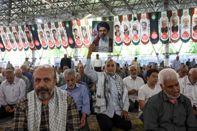 A citizen holds a photo of Supreme Leader Ali Khamenei during Friday prayers in Tehran, Iran, on June 12, as the U.S. and Iran finalize their MOU to end hostilities.