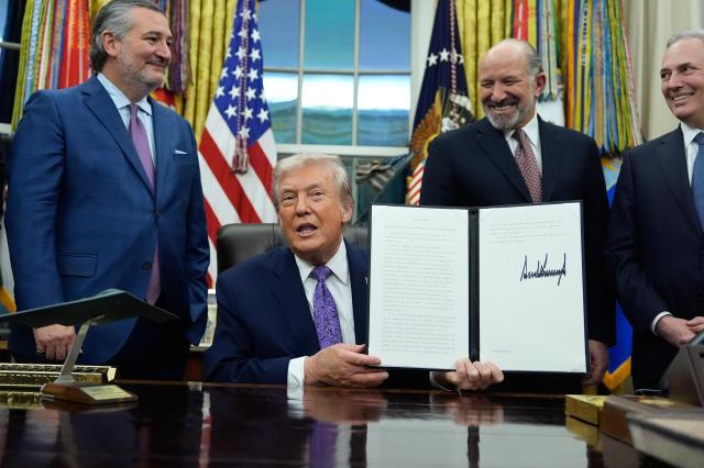Flanked by Sen Ted Cruz R-Texas left Secretary of Commerce Howard Lutnick second right and White House AI and Crypto Czar David Sacks President Donald Trump displays his signed AI initiative in the Oval Office of the White House in Washington on Dec 11 2025 AP-Yonhap
