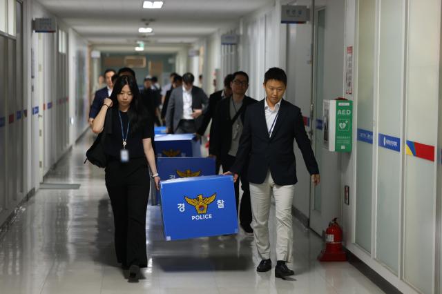 Officials from a joint police-prosecution task force carry boxes of seized materials as they leave the Seoul Metropolitan Election Commission in Seouls Jongno-gu on June 11 2026 following a search and seizure operation related to the June 3 local election ballot shortage controversy Yonhap 