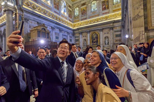 South Korean President Lee Jae Myung poses for a group photo with attendees after a special Mass for peace and solidarity celebrated by Cardinal Lazarus You Heung-sik at the Basilica of Saint Paul Outside the Walls in Rome Italy on June 14 2026 Yonhap 