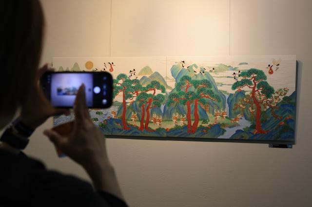 A visitor takes photo of a painting in Nexons game arts exhibition at Nexon Koreas headquarters in Seongnam June 16 2026 AJP Han Jun-gu 