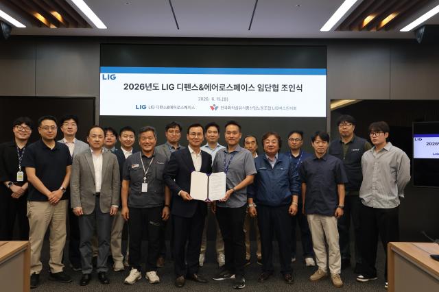 LIG D&A officials pose for a commemorative photo during the signing ceremony for the 2026 wage and collective bargaining agreement held on June 15 at the Pangyo House.