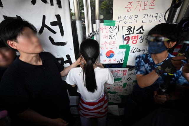  6·3 지방선거 투표용지 부족 사태로 시작한 서울 송파구 올림픽공원 핸드볼경기장 일대 개표소 봉쇄 시위가 이어지는 가운데 16일 한 시위 참가자가 대한체육회 등 입주 단체 관계자들의 진입을 막아서고 있다 사진연합뉴스