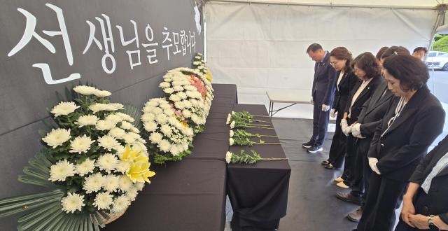 Senior officials of the Jeju Provincial Office of Education pay tribute at a memorial space set up in the office parking lot on May 20 2026 to mark the first anniversary of the death of a middle school teacher The teacher a man in his 40s died by suicide after leaving a note having allegedly endured around-the-clock complaints from a students family through his personal cellphone before he was found dead at a middle school in Jeju Yonhap 