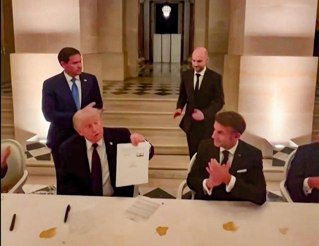 This videograb from footage made available on June 18 2026 from the X account of French President Emmanuel Macron shows US President Donald Trump left and Frances President Emmanuel Macron right during the signing of a deal with Iran to end the Middle East war inside Chateau de Versailles in Versailles southwest of Paris on June 17 2026 
