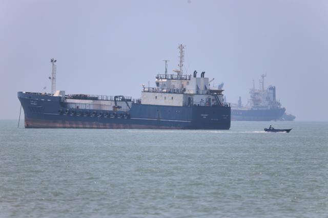 A small motorboat passes anchored vessels in the Strait of Hormuz off Bandar Abbas Iran on June 17 2026 AP-Yonhap
