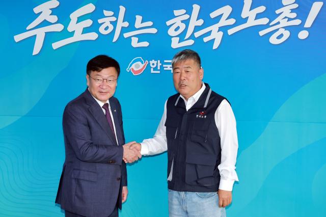 Jung Jeom-sik, leader of the People Power Party, shakes hands with Kim Dong-myung, chairman of the Korean Confederation of Trade Unions, during a visit on June 19 in Yeouido, Seoul.