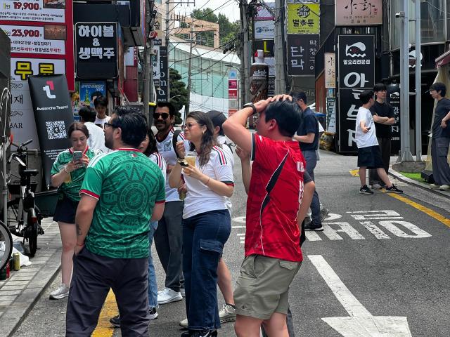 Gloria Romanez in her Mexico uniform is watching the match between Korea and Mexico alongside the bar in Gangnam district with her friends AJP Joonha Yoo