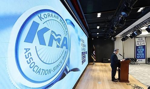 A speaker delivers remarks at a Korean Medical Association briefing as the association’s logo is displayed on a large screen Courtesy of Yonhap News Agency