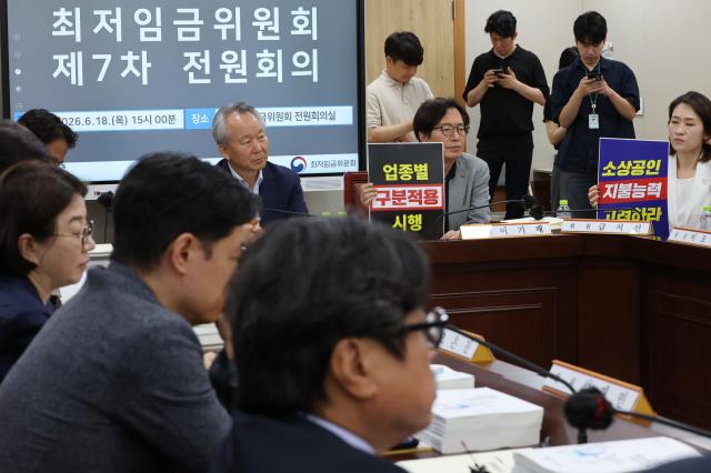 18일 정부세종청사 최저임금위원회에서 열린 제7차 전원회의에서 사용자 위원들이 최저임금의 업종별 구분적용을 요구하는 피켓을 들고 있다 사진연합뉴스