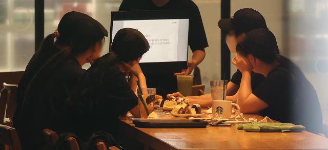Starbucks employees review training materials after the company closed stores nationwide early at around 3 pm in Daegu on June 22 2026 The early closure was part of a company-wide education program aimed at strengthening historical awareness and social sensitivity following last months marketing controversy Yonhap
