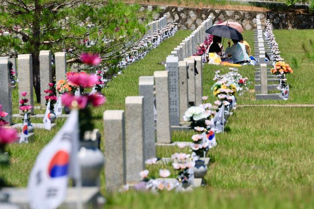 Visitors talk among themselves before grave markers at Seoul National Cemetery in Dongjakdong Dongjak-gu Seoul on June 23 2026 AJP Han Jun-gu