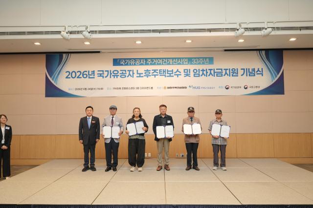 최인호 주택도시보증공사HUG 사장왼쪽에서 첫 번째이 24일 개최된 행사에서 국가유공자 대표에게 기증서를 수여한 후 기념촬영을 하고 있다 사진HUG