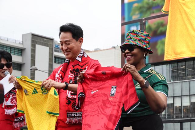 Seoul Mayor Oh Se-hoon exchanges national team jerseys with South African Ambassador to South Korea Cindy Mkhize at the Red Devils cheering zone in Gwanghwamun Square, Seoul, on June 25, 2026. AJP Yoo Na-hyun.