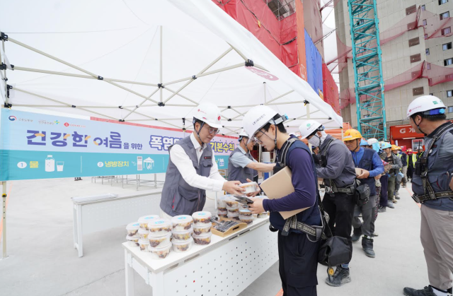 오일근 롯데건설 대표맨 왼쪽가 지난 25일 경기도 오산시에 위치한 ‘롯데캐슬 위너스포레’ 건설현장에서 혹서기 온열질환 예방 캠페인을 진행하고 근로자들에게 팥빙수와 이온음료 혹서기 용품 등을 나눠주고 있다 사진롯데건설