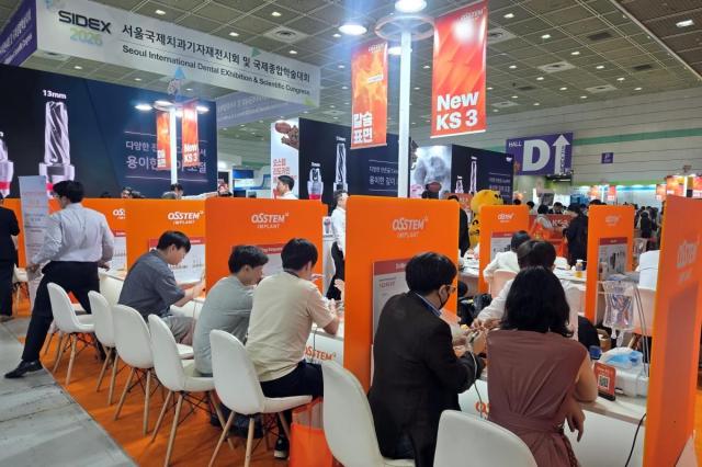 2026年5月29日から31日まで、ソウル江南区のCOEX展示ホールで開催された『2026ソウル国際歯科機器展示会』で、歯科医師の来場者がオステムインプラントのブースを訪れ、インプラント新製品『New KS 3』を実習体験している。