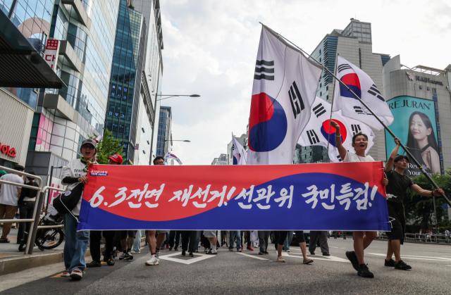 Participants march through the Hongdae area during a rally calling for a presidential election rerun organized by the conservative youth group BOSS Hongdae in Seoul on June 27, 2026. AJP Yoo Na-hyun


