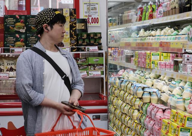 A tourist looks at banana-flavored milk displayed on a shelf at a grocery store in Myeong-dong, central Seoul, on June 29, 2026. AJP Yoo Na-hyun