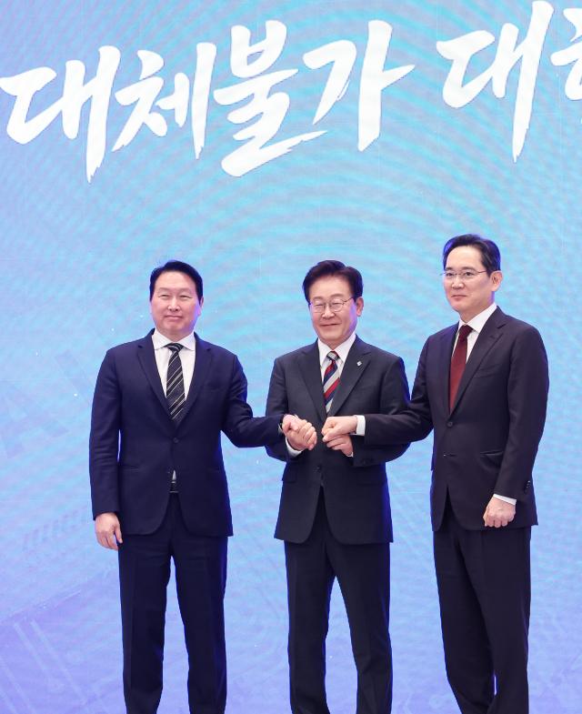 President Lee Jae Myung hold hands with Samsung Electronics chairman Jay Y Lee and SK Group chairman Chey Tae-won after they jointly announce multi-trillion-won project to build chip and AI clusters across the country on June 29 2026 Pool photo