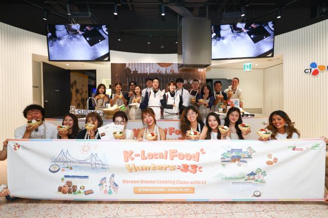 Overseas influencers taking part in the K-Local Food Hunters 33 campaign show off bowls of bibimbap during a Korean cooking class at CJ The Kitchen in Seoul on Monday Courtesy of Korea Tourism Organization 