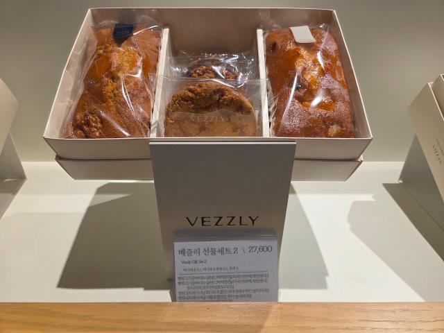 The 'Bezzly Gift Set 2,' which includes mini pound cakes and five cookies, is displayed at the Bezzly store in Hyundai Department Store's Sinchon branch. The ingredient list indicates the use of liquid egg made from Chinese eggs.