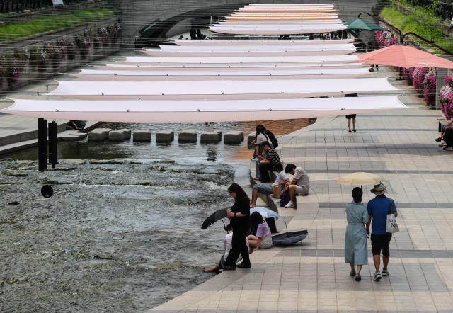 Residents cool off by the Cheonggyecheon Stream in central Seoul on June 30 as a heat advisory remains in effect across the capital AJP Yoo Na-hyun

