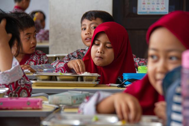Students eat free meals at a school in Indonesia XinhuaYonhap