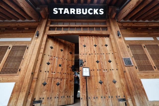 An employee posts a notice announcing the early closure of the store at around 3 pm and locks the entrance at a Starbucks outlet in Daegu on June 22 2026 Starbucks Korea said it closed all of its stores nationwide at 3 pm that day following the controversy over its Tank Day marketing campaign and conducted company-wide training to enhance employees historical awareness and social sensitivity Yonhap 
