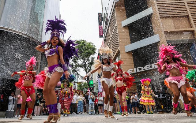 Lotte World Adventure performers stage a samba performance to celebrate the opening of the theme parks summer festival on UNESCO Street in Seouls Myeong-dong district on July 1 2026 AJP Yoo Na-hyun